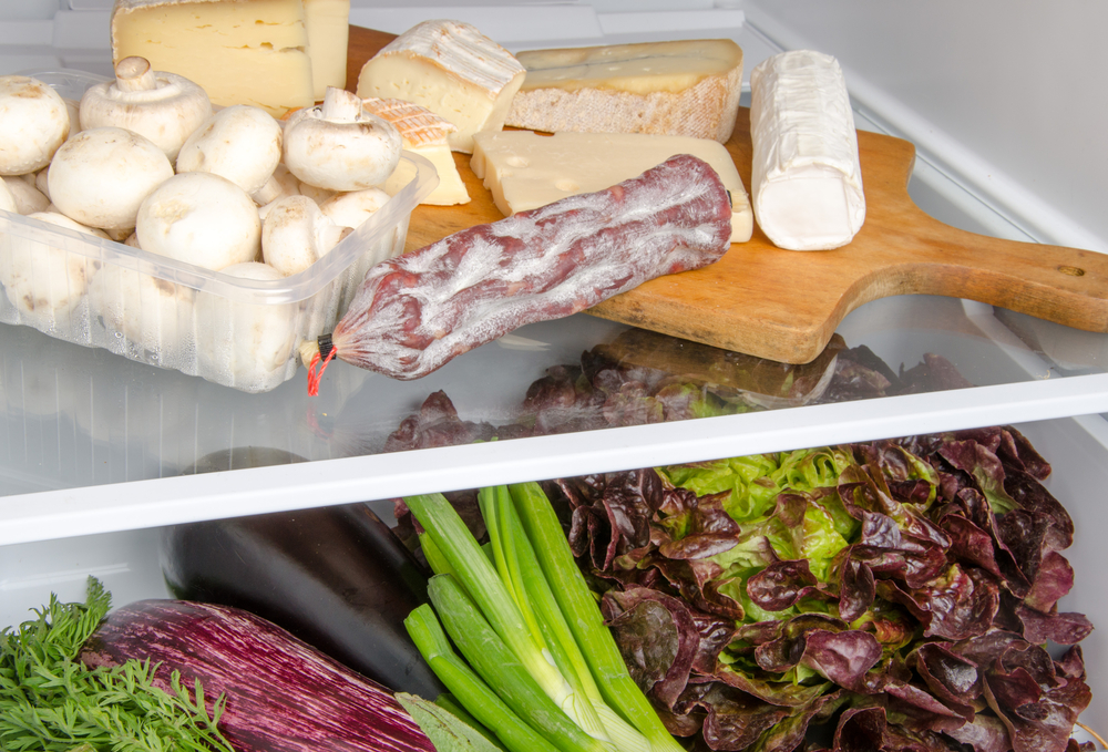 Сыр на разделочной доске в холодильнике