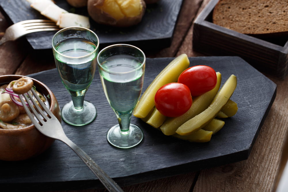 Водка с закуской - маринованными огурчиками, помидорами и солеными грибами