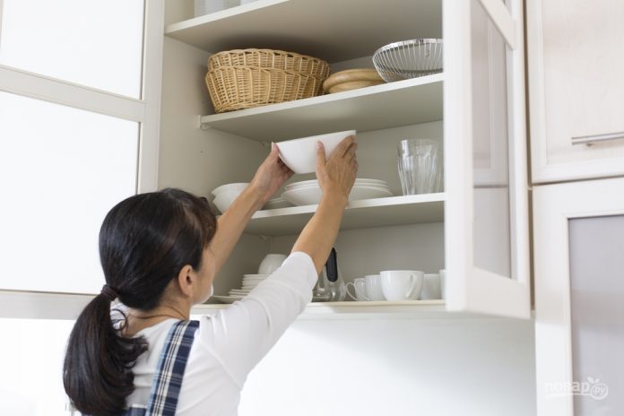 jenshina_raskladivaet_posudu_v_kuhne-515642