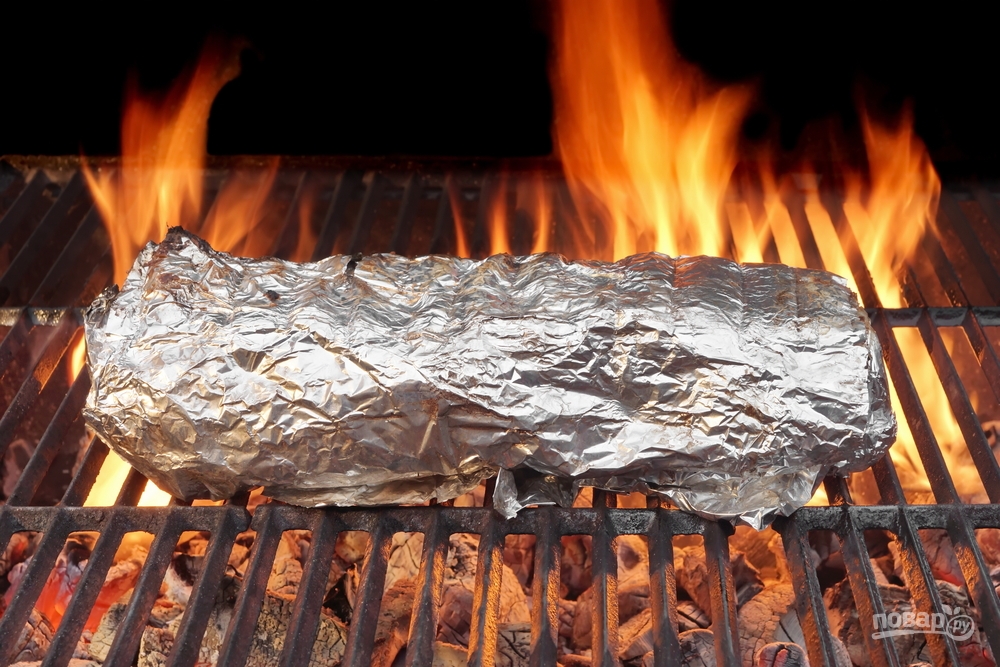 Мясо в фольге запекается на гриле